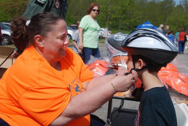 Debbie Woelfel, EMS system coordinator at Alton Memorial Hospital, fits a child with a helmet during last year&rsquo;s Family Safety Fest.