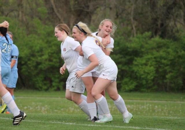 Kassie Turner gets tackled by her teammates in celebration of her goal.