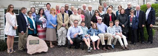 Dr. David Jenkins is surrounded by family, friends and former colleagues while seated on a bench dedicated in his name to the SIU School of Dental Medicine.