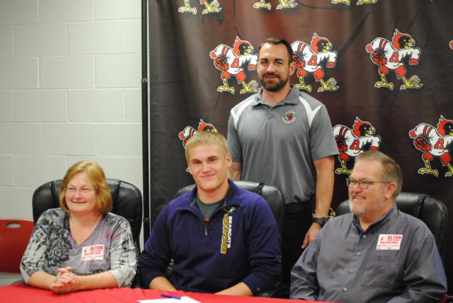 Zach Llewellyn (center front) with his mom Chris and dad Chris with AHS throws coach Eric Dickerson in the back.