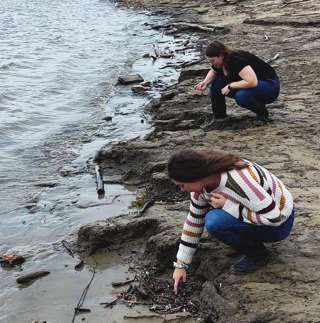 NGRREC Staff Hannah Griffis and Jen Young looking for small pieces of plastic called nurdles on the banks of the Mississippi River. Photo by Danelle Haake, RiverWatch Director and Stream Ecologist, NGRREC