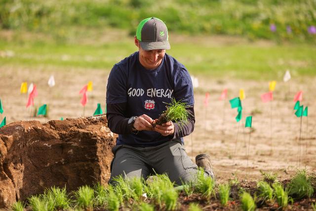 Wood River Refinery employee puts new native plants in the ground at the Swansea Clinton Hills Conservation Park.