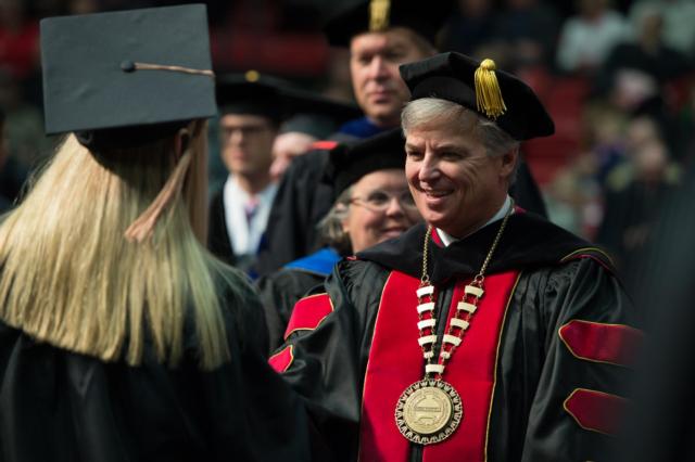 SIUE Chancellor Randy Pembrook congratulates a graduate at the 2016 fall commencement ceremony. 