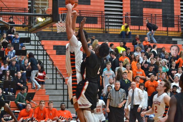 A.J. Epenesa has a rare leaping ability, demonstrated in this slam dunk. Looking on is Edwardsville basketball coach Mike Waldo. Epenesa holds Waldo in very high regard as a coach. (Photo by Dan Brannan)