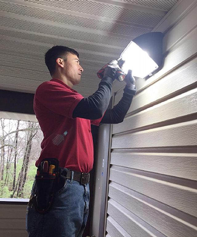 David Balai, UHFM electrician, installs new LED lighting in Cougar Village.