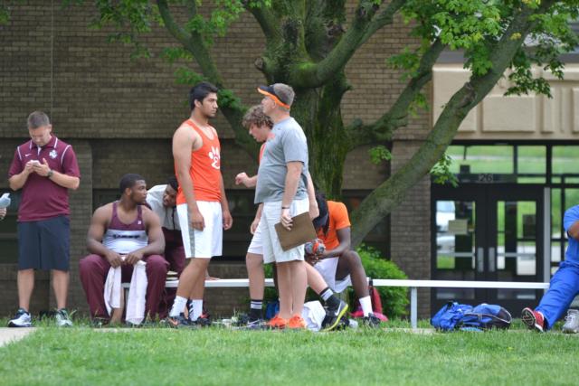 A.J. Epenesa and his coach Matt Martin confer prior to his record throw of 194-3.5 in the discus at the Collinsville Invitational. (Photo by Dan Brannan)