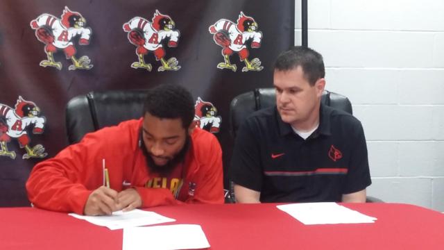 Maurice Edwards signs his letter with Redbird coach Eric Smith looking on