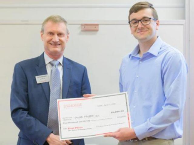 SIUE School of Business Dean Tim Schoenecker awards senior Adam Morris with the $5,000 first-place prize for his business idea, Power Frisbees.