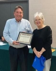 John Rain (left) was presented with Godfrey's Good Neighbor award by Trustee Sarah Woodman (right).