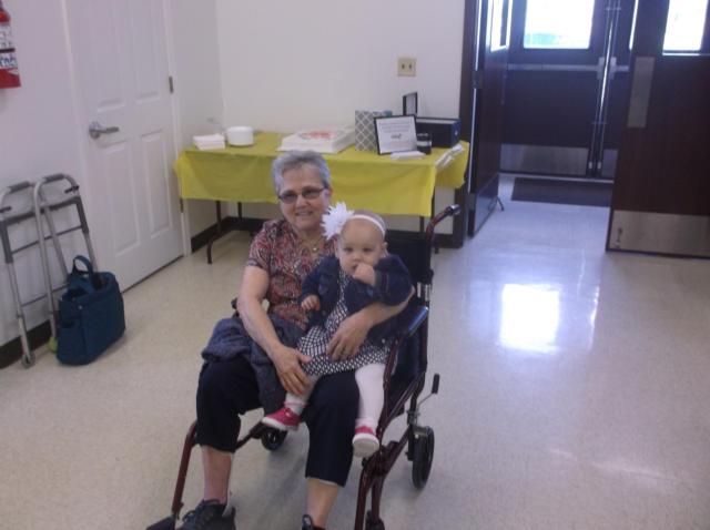 Janet Laubscher sits with her 1-year-old granddaughter, Cadence Kolkmeyer before partaking in a luncheon in her honor