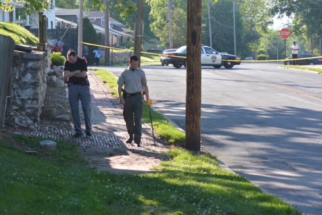 Investigators probe the area near where an apparent shooting occurred early Sunday morning. (Photo by Dan Brannan)