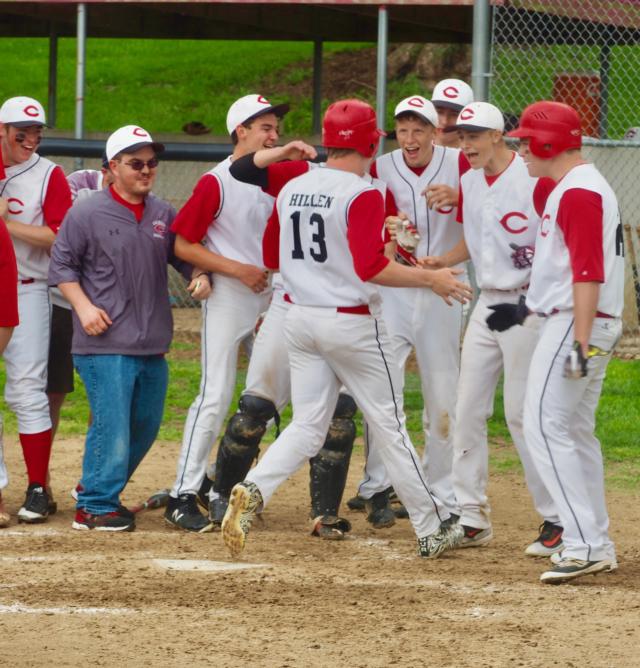 A.J. Hillen gets mobbed by his teammates at home plate after hitting a go-ahead home run.