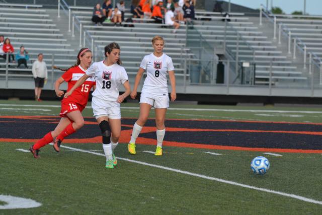 Alton freshman Katie Kercher moves to the ball with Kendyl Pritchett (18) and Kendell Paterson (8). (Photo by Dan Brannan)