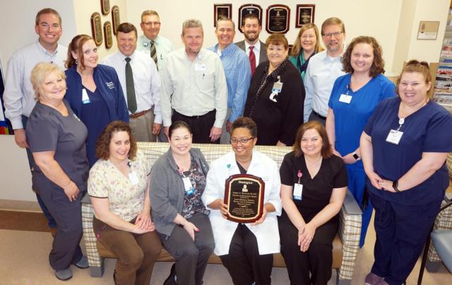 The Alton Memorial Hospital Center for Wound Care and Hyperbaric Medicine staff was congratulated recently by AMH leadership for earning another Center of Excellence Award. Wound Care staff includes, seated left to right, Tonya Strohbeck (HBO safety director), Kary Holliday (staff RN), Dr. Valinda Allen (medical director), Kathy Ridenhour (staff RN). Standing left to right, Tammy Miller (front office coordinator), Matt Flick (director), Ashely Cline (staff RN), AMH President Dave Braasch; Perry Hartwick of AMH, Brad Goacher of AMH, Rusty Ingram of AMH, Brian Cook (Healogics area vice president), Debbie Turpin of AMH, Pat Beach (Healogics Regional Director of Clinical Operations), Dr. Sebastian Rueckert of AMH, Jana Lybarger (nurse manager), and Megan Hanson (staff LPN)