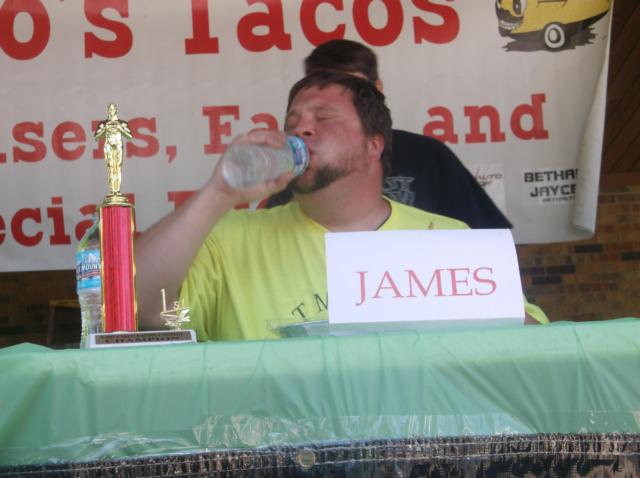 Winner James Weihl pauses for a drink of water before finishing all 10 tacos in front of him