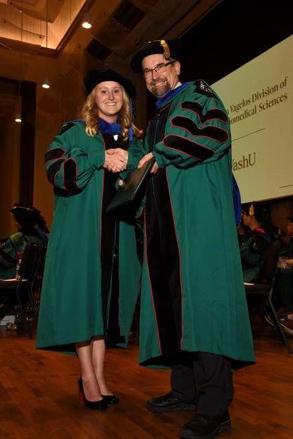 Dr. Jenna Eschbach receiving her PhD degree conferral from Dr. Steve Mennerick.