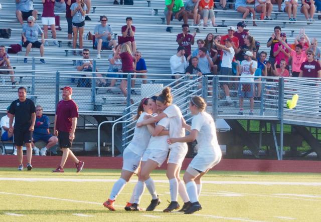 Addison Hanusek (2) is mobbed by her teammates after scoring a 39-yard free kick.