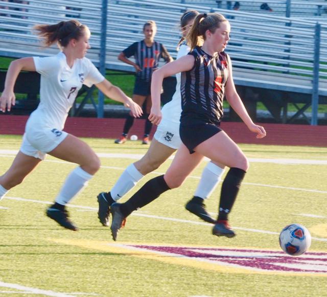 Edwardsvile's Paityn Schneider (9) tries to dribbles away from two Maroons.