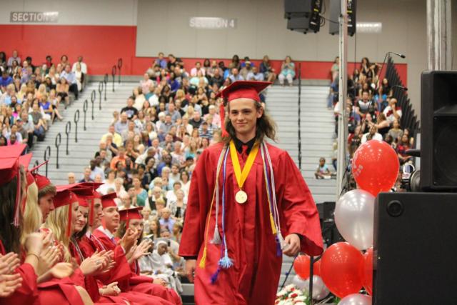 John Bohn received the distinction of Valedictorian in the evening's commencement exercises. He is seen here, taking his walk back to his seat after his commencement speech. 