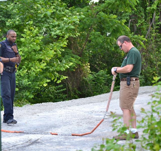 The area where the construction accident on Thursday occurred was brushy as shown here. Officers are preparing to rope off the area. (Photo by Dan Brannan)