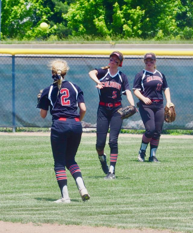 Junie Zirkelbach throws the softball to Sophie Lorton at second base.
