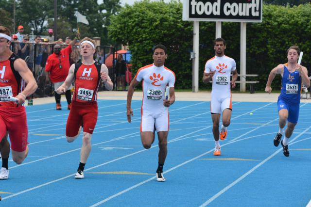 Devonte' Tincher accepts the handoff for the second leg of the 4 x 100 relay on Saturday at the IHSA State Track and Field Meet. (Photo by Dan Brannan)