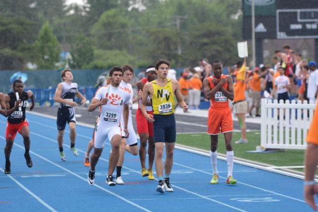 Jack Lever hands off to Suleman Bazai for the final leg of Edwardsville's 4 x 400 relay. (Photo by Dan Brannan)