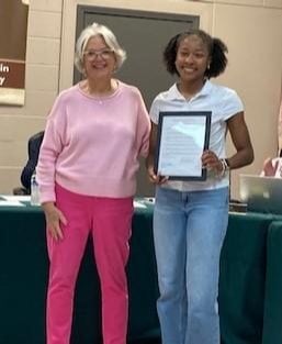 Trustee Sarah Woodman (left) honors Rayna Raglin (right) with the proclamation on June 2, 2026.