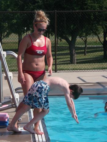 The instructor, Cori Goetten, observes Jake Wilkinson, 10, as he demonstrates his dive.