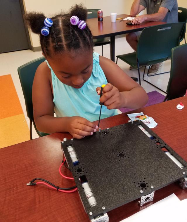 Meachum and Gateway resident participants work on building the rover, and practice operating it.