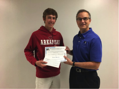 Isaac Bertels receives an award and $500 college scholarship from Heneghan and Associates Engineer Curt Westrich.