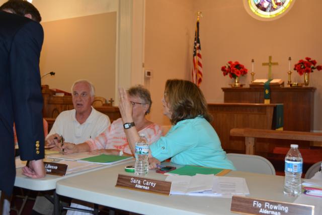 Sara Carey has an exchange with Mayor Tom Thompson and City Attorney Jim Schrempf before Tuesday's meeting.