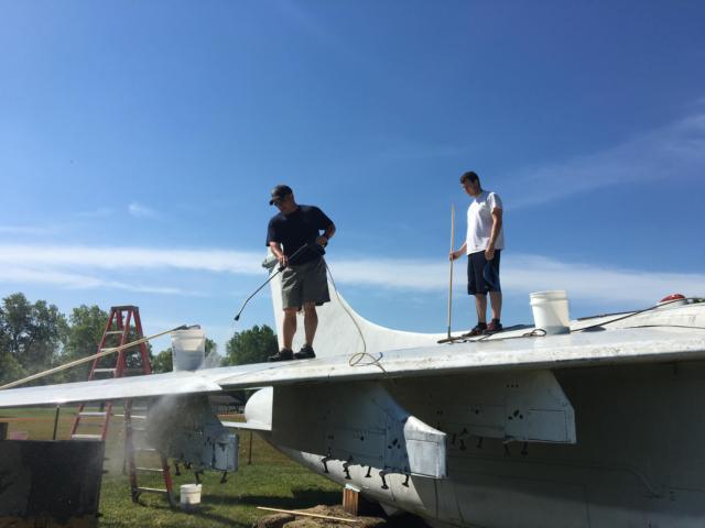 Volunteers with the Flight Deck Veterans Group and the community wash more than 25 years of dirt and debris off the aircraft.