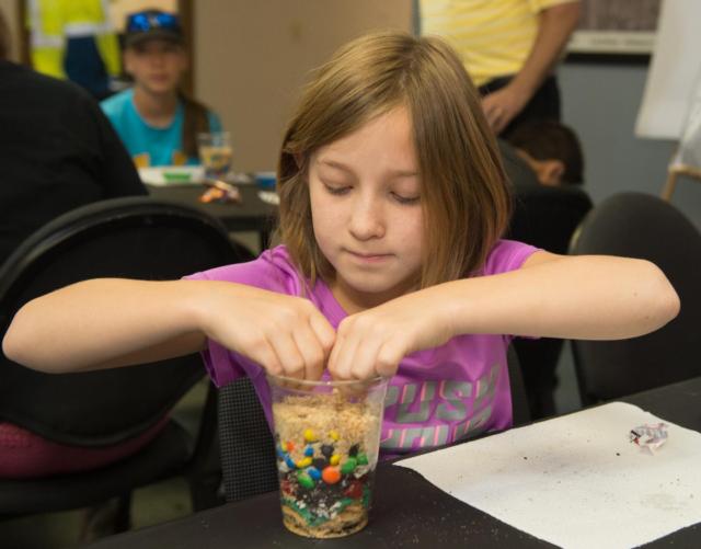 Campers happily engaged in a hands-on activity that taught them about the layering processes at landfills.