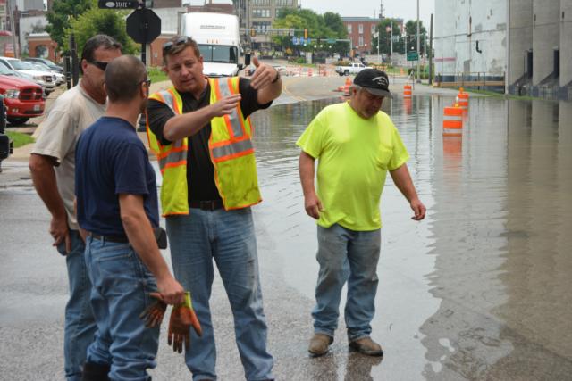 Alton Public Works Director Bob Barnhart instructs some of his employees in Downtown Alton prior to installing barriers.