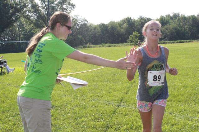 Kendal Davis, then 10 years old, crossed the finish-line with a high-five from event volunteer, Caitlyn Dixon.