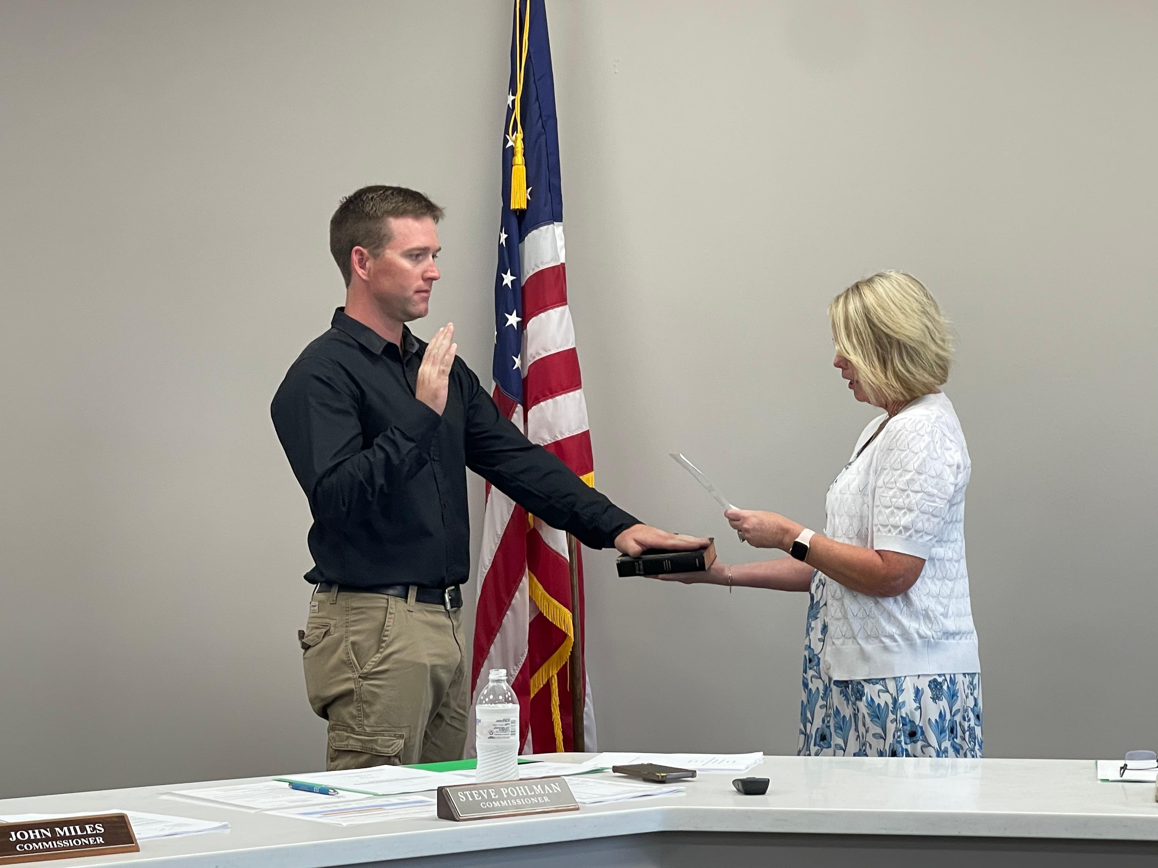 Patrolman Austin Laing (left) takes the Oath of Office administered by City Clerk Denise Hayes (right).