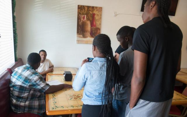 A group of students participating in SIUE’s Digital East St. Louis program record an interview with an employee at Sherry J’s restaurant in East St. Louis. The interview will be part of a documentary they are creating on the topic of soul food.