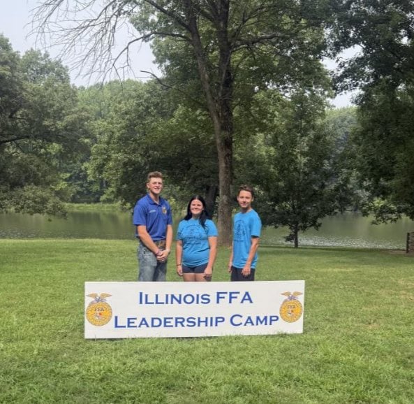Section 15 President Mason Volentine poses with Caitlyn Stafford and Mason Morfey at Illinois Leadership camp sign.