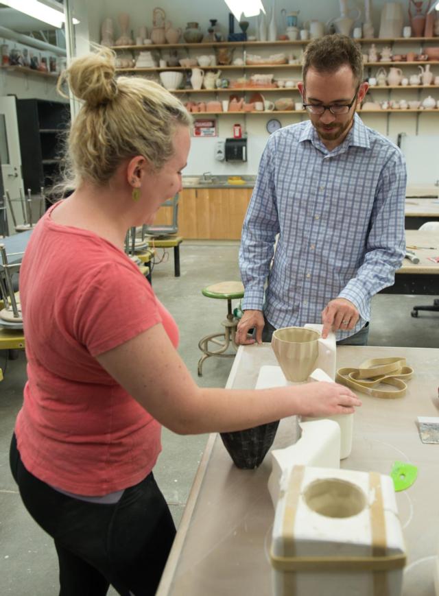 Joe Page, assistant professor of ceramics in the SIUE Department of Art and Design works with graduate student Caitlin McDonald.