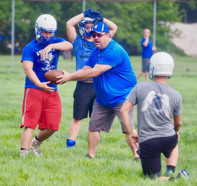 North Greene head coach Donnie Allen demonstrates a play to his offense at North Greene High School last week. Allen is ready to begin his first season as the Spartans head coach.