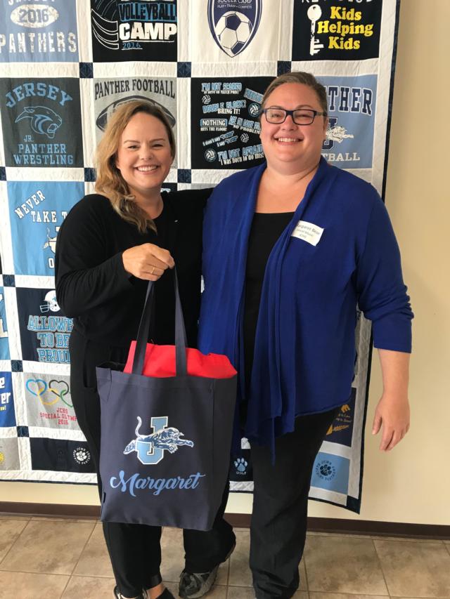 JCBA Director Beth Bear presents a welcome bag to her sister Margaret Bear, who is the new choral director at Jersey Community High School. 