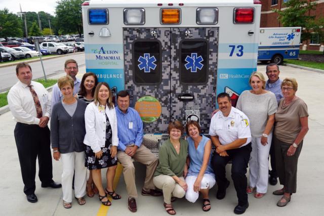 AMH leadership and Duck Pluckers committee members with the new ambulance include, left to right, Bryan Hartwick, vice president of Human Resources; Dr. Sebastian Rueckert, VP/chief medical officer; Marlene Lewis, manager of Foundation and Development; Nancy Simpson of the Duck Pluckers committee; Susan Koesterer, vice president of Finance; Dave Braasch, president of AMH; Jeanne Truckey of the AMH Development office; Joanne Adams of the Duck Pluckers committee; Jason Bowman, EMS supervisor; Gaye Julian of the Duck Pluckers committee; Rusty Ingram, director of Business Development; and Mary Lou Cousley of the Duck Pluckers committee.