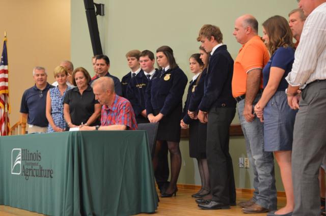 Pittsfield FFA students and Rep Davidsmeyer watch as IL Governor Bruce Rauner signs HB470.