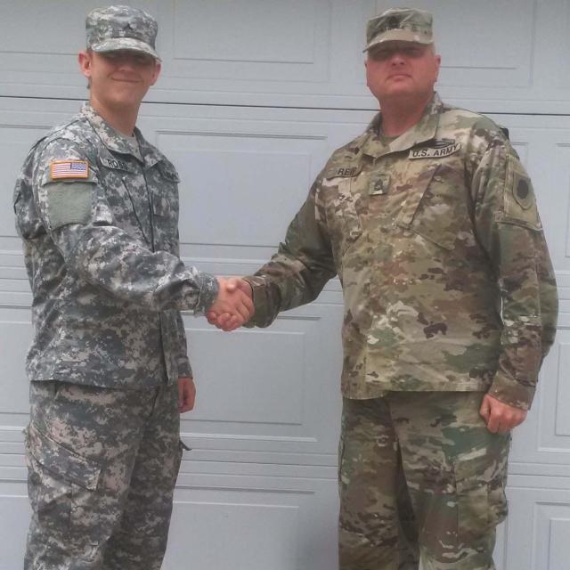 Pvt. Michael Ross of Gillespie, Illinois, shakes hands with Sgt. 1st Class Thomas Reif, a recruiter with Illinois National Guard at Ross’s home in Gillespie.