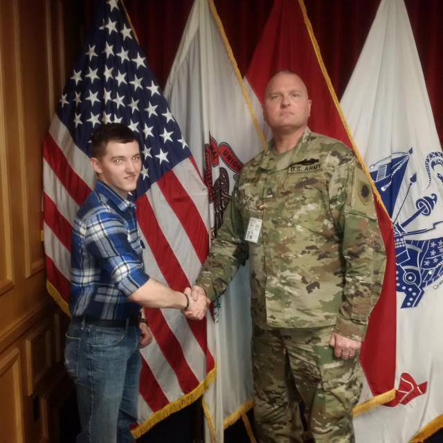Spc. James Smith of New Douglas, Illinois, shakes hands with Sgt. 1st Class Thomas Reif, a recruiter with Illinois National Guard at the St. Louis Military Enlistment Processing Station.