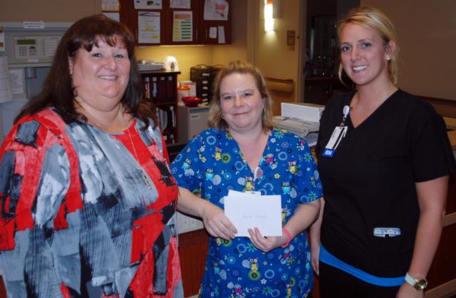 Heather Hamburg of the Alton Memorial Hospital Intermediate Care Unit, center, is congratulated by AMH chief nurse executive Debbie Turpin and IMU team leader Cassie Beck for the Awesome Card that Heather received from a patient for the excellent care she provided in late June.