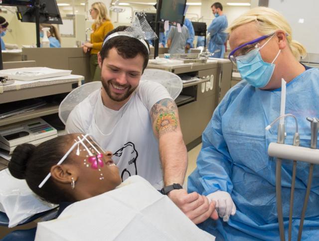 The tooth fairy helps a dentist work with a young patient at the SIU School of Medicine’s 2016 Give Kids a Smile day.