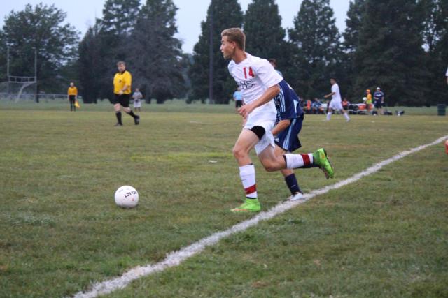 AHS junior midfielder Noah Henry keeping the ball from passing the out of bounds line. 