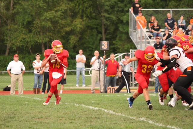Quarterback Marcus Hartnett drops for a pass on Friday night. (Photo by Madelaine Gerard)